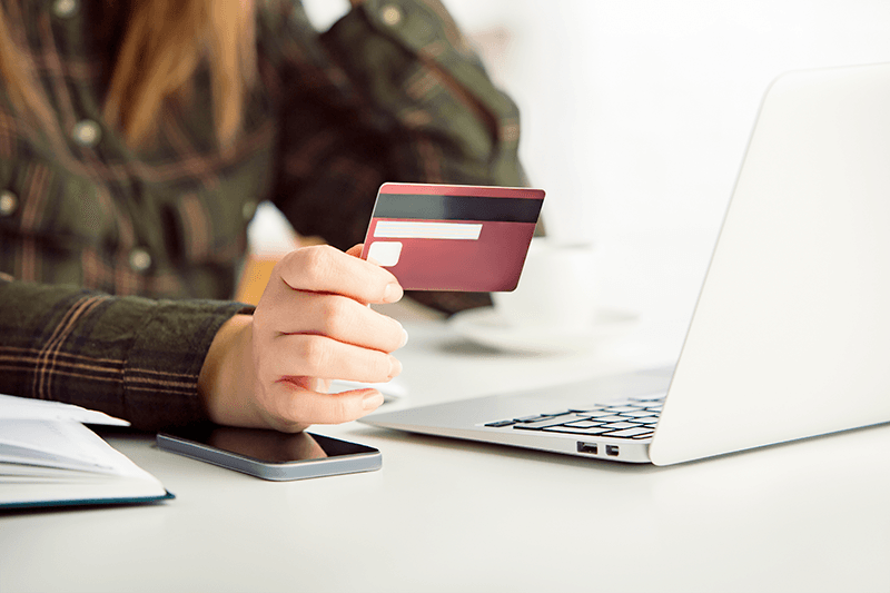Consumidor segurando um cartão de crédito ao comprar em uma loja feita no WooCommerce